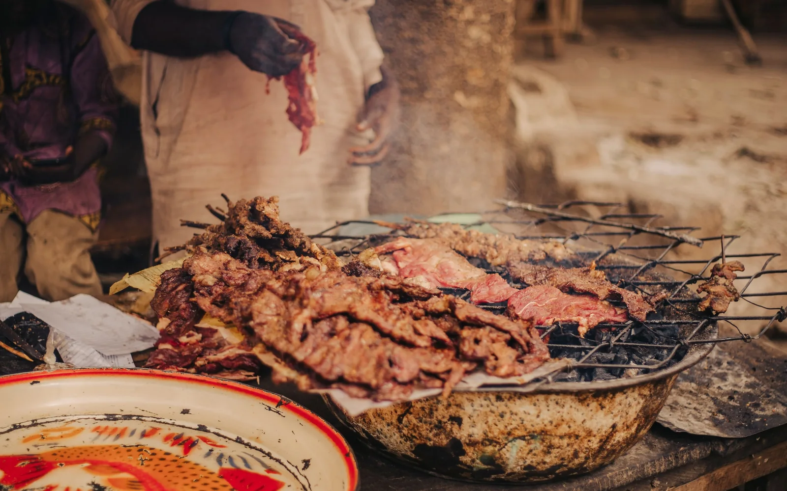 Grillowane mięso krojonę i podawane z otwartego grilla węglowego na straganie z jedzeniem ulicznym w Afryce (reprezentatywne zdjęcie grillowania w stylu nyama choma, nie własny grill Nyama Choma Ranch)